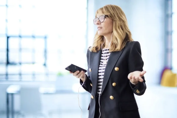 Ofiste Oturup Video Görüşmesi Yaparken Akıllı Telefon Kulaklık Kullanan Orta — Stok fotoğraf