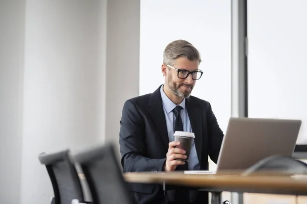Střední Dospělý Podnikatel Sedí Stolu Notebookem Pije Kávu Při Práci — Stock fotografie
