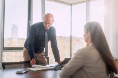 Teamwork at the office. Businessman standing at office desk and consulting with his colleague.