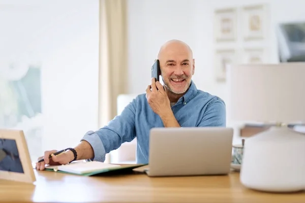 Happy Middle Aged Man Making Call Using Laptop While Working — Stok fotoğraf