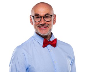Close-up of mid aged man wearing glasses and bow tie and standing at isolated white background. Copy space.