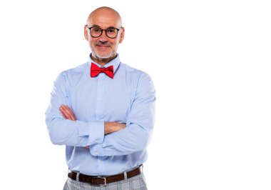 Close-up of mid aged man wearing shirt and bow tie and standing at isolated grey background. Copy space.