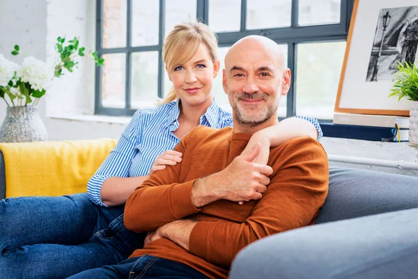 Shot Married Couple Embracing Sofa Happy Woman Man Wearing Casual — Stok Foto
