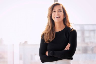 Çekici bir kadının portresi dişlek gülümseyen ve kameraya bakan. Siyah kazak giyen ve kolları çapraz duran sarışın kadın. Boşluğu kopyala. 