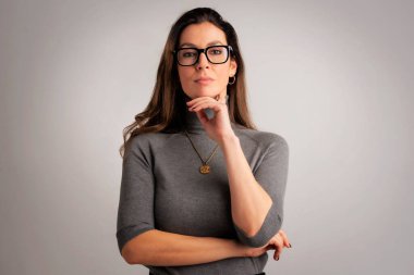 Süveter giyen, balıkçı yaka kazak giyen ve izole edilmiş gri arka planda duran orta yaşlı çekici bir kadının stüdyo portresi. Uzayı kopyala Stüdyo çekimi.