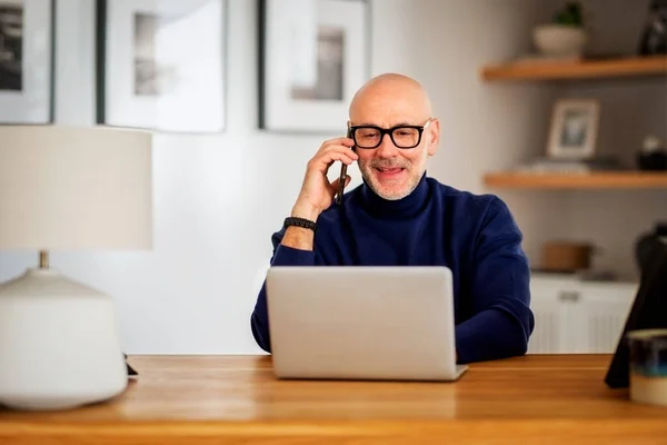 Happy Middle Aged Man Making Call Using Laptop While Working —  Fotos de Stock