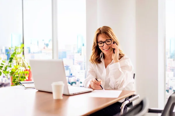Wanita Bisnis Paruh Baya Duduk Kantor Modern Dan Memiliki Panggilan — Stok Foto