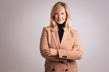 Çekici bir kadının portresi gülümseyen ve kameraya bakan. Sarı saçlı, spor ceket giyen ve izole edilmiş beyaz arka planda duran bir kadın. Uzayı kopyala Stüdyo çekimi. 