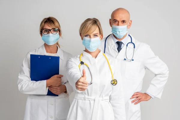 Aufnahme Eines Ärzteteams Das Gesichtsmasken Trägt Und Vor Isoliertem Hintergrund — Stockfoto