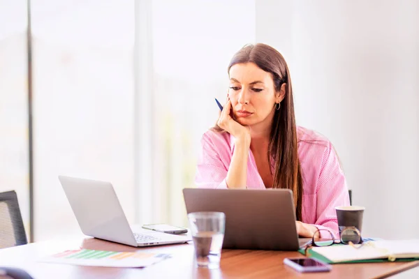 坐在办公桌前 在现代化的办公室里工作时 想着女商人使用笔记本电脑 — 图库照片