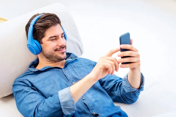 Hombre Sonriente Con Auriculares Usando Teléfono Móvil Escuchando Música —  Fotos de Stock