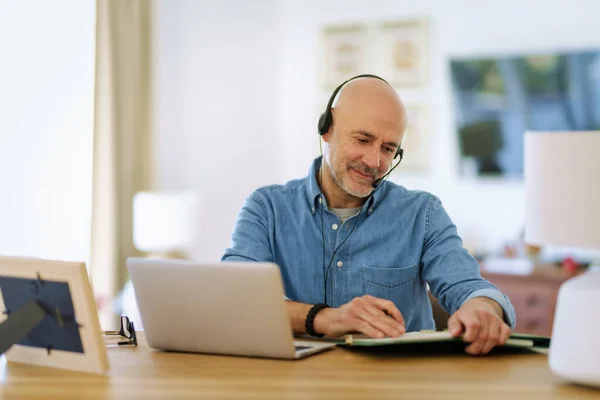 客户服务助理坐在笔记本电脑后面 头戴耳机 在呼叫中心工作 英俊的商人穿着斜纹棉布衬衫 — 图库照片