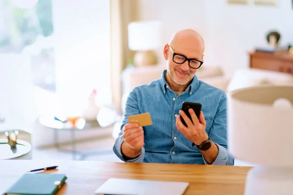 Homem Meia Idade Sentado Casa Usando Cartão Crédito Telefone Celular — Fotografia de Stock