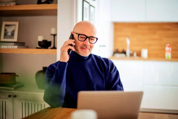 Confident Middle Aged Man Making Call Using Laptop While Working — Stock fotografie