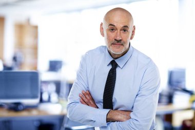 Ofiste duran ve şaşırmış görünen bir adam. İş adamı gömlek ve kravat takıyor..