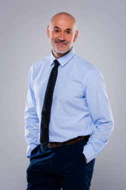 Orta yaşlı, gömlek ve kravat takan ve arka planda duran bir adamın fotoğrafı. Boşluğu kopyala.