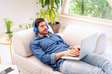 Evde müzik dinlerken kulaklık takan orta yaşlı yakışıklı bir adamın fotoğrafı.. 
