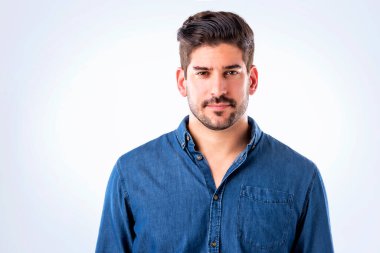 Yakından bakınca, gömlek giyen ve beyaz arka planda duran yakışıklı bir adam. Uzayı kopyala Stüdyo çekimi.