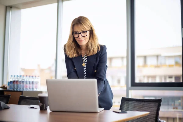 拍了一个自信的成熟的女商人有视频通话而站在一个现代化的办公室 职业女性戴着眼镜和夹克 — 图库照片