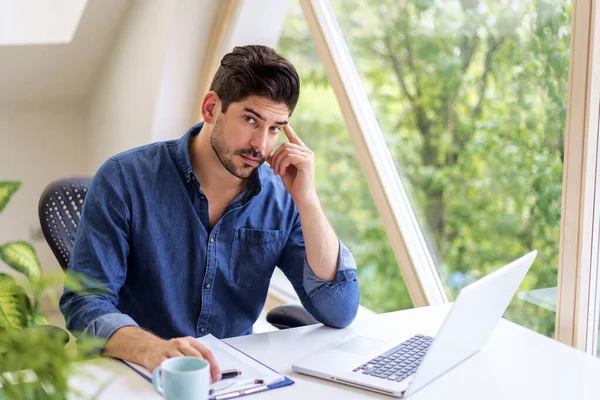 Hombre Con Cara Rastrojo Sentado Mesa Mirando Pensativamente Está Usando —  Fotos de Stock