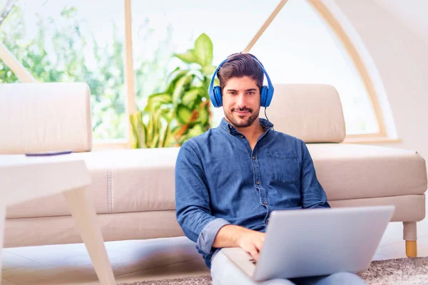 Homem Está Sentado Chão Casa Com Fones Ouvido Laptop Ligado — Fotografia de Stock