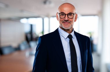 Ofisteki kendinden emin iş adamının portresi. Takım elbise ve kravat takan orta yaşlı profesyonel bir adam. Boşluğu kopyala. 