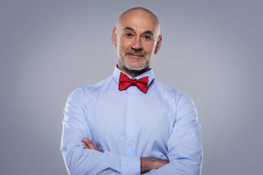 İzole edilmiş gri arka planda gömlek ve papyon takan orta yaşlı bir adamın yakın çekimi. Boşluğu kopyala. 