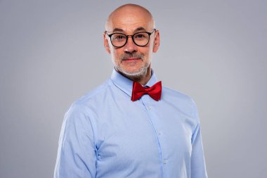 İzole edilmiş gri arka planda gömlek ve papyon takan orta yaşlı bir adamın yakın çekimi. Boşluğu kopyala. 