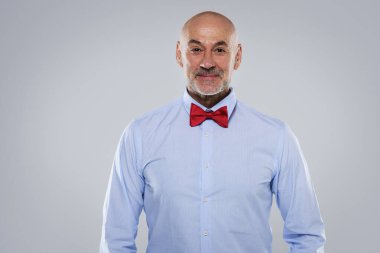 İzole edilmiş gri arka planda gömlek ve papyon takan orta yaşlı bir adamın yakın çekimi. Boşluğu kopyala. 