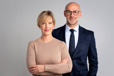 Bir grup sarışın iş kadını ve soyutlanmış geçmişi olan orta yaşlı iş adamı. Çekici profesyonel kadın kameraya bakıyor ve gülümsüyor. İş ekibi. Boşluğu kopyala. 