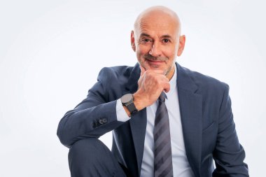 Orta yaşlı iş adamı takım elbise ve kravat takıyor ve izole edilmiş beyaz arka planda oturuyor. Boşluğu kopyala. 