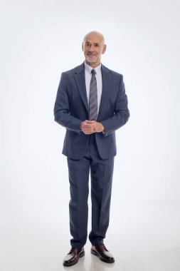 Orta yaşlı işadamı takım elbise giyip izole edilmiş arka planda kravat takıyor. Beyaz arka planda duran kendine güvenen bir adam. Uzayı kopyala Tam boy çekim. 