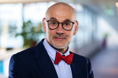 Ofiste duran orta yaşlı bir iş adamının yakın çekimi. Takım elbiseli ve papyonlu profesyonel bir adam.. 