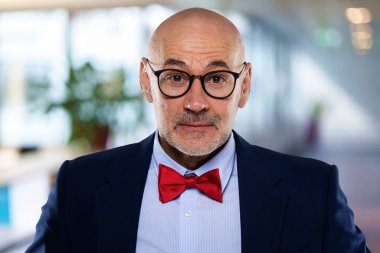 Ofiste duran orta yaşlı bir iş adamının yakın çekimi. Takım elbiseli ve papyonlu profesyonel bir adam.. 