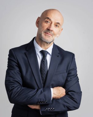 İzole edilmiş beyaz arka planda duran orta yaşlı iş adamının stüdyo portresi. Profesyonel erkek takım elbiseli ve kravatlı. Boşluğu kopyala.