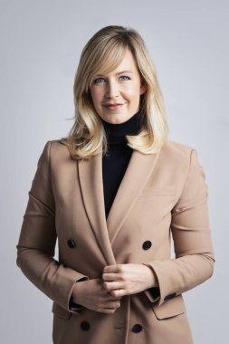 İzole edilmiş beyaz arka planda duran çekici sarı saçlı kadın. Siyah kazak ve ceket giyen olgun bir kadın. Boşluğu kopyala.