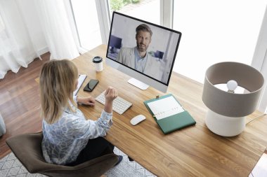 İş kadını bilgisayarın arkasında oturmuş web konferansı yapıyor. Merkez Ofis.