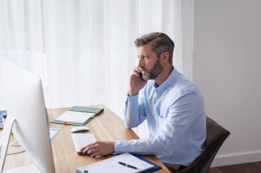 Evde oturup akıllı telefon ve bilgisayar kullanan kendine güvenen bir adam. Orta yaşlı işadamı arıyor. Merkez Ofis. 