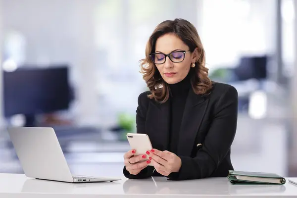 Geschäftsfrau Mittleren Alters Sitzt Büro Und Nutzt Laptop Und Smartphone — Stockfoto