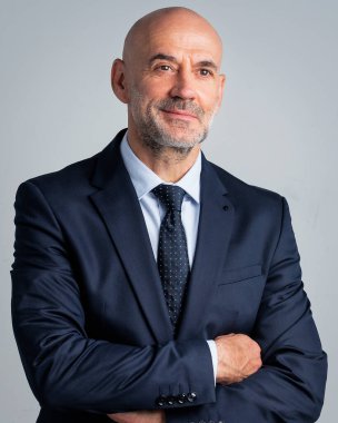 Orta yaşlı işadamı takım elbise giyip izole edilmiş arka planda kravat takıyor. Beyaz arka planda duran kendine güvenen bir adam. Boşluğu kopyala.