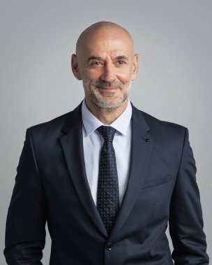 Orta yaşlı işadamı takım elbise giyip izole edilmiş arka planda kravat takıyor. Beyaz arka planda duran kendine güvenen bir adam. Boşluğu kopyala.