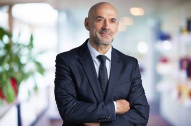 Orta yaşlı iş adamı takım elbise ve kravat takıyor ve ofis lobisinde dikiliyor. Boşluğu kopyala.