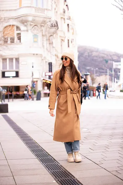 一个头发乌黑的中年妇女走在市中心的大街上 穿着太阳镜和冬衣的迷人女性 — 图库照片