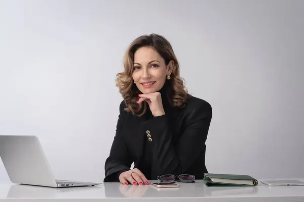 Geschäftsfrau Mittleren Alters Sitzt Schreibtisch Vor Isoliertem Weißen Hintergrund Selbstbewusste lizenzfreie Stockbilder