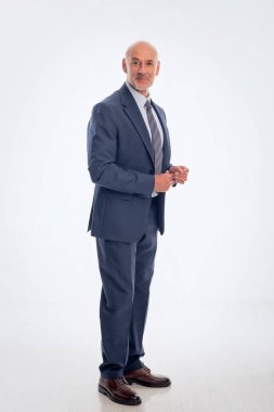 Orta yaşlı işadamı takım elbise giyip izole edilmiş arka planda kravat takıyor. Beyaz arka planda duran kendine güvenen bir adam. Uzayı kopyala Tam boy çekim. 