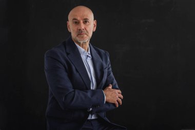 Ciddi yüzlü iş adamının takım elbise giyip, izole edilmiş gri arka planda dikilirken görüntüsü. Boşluğu kopyala.