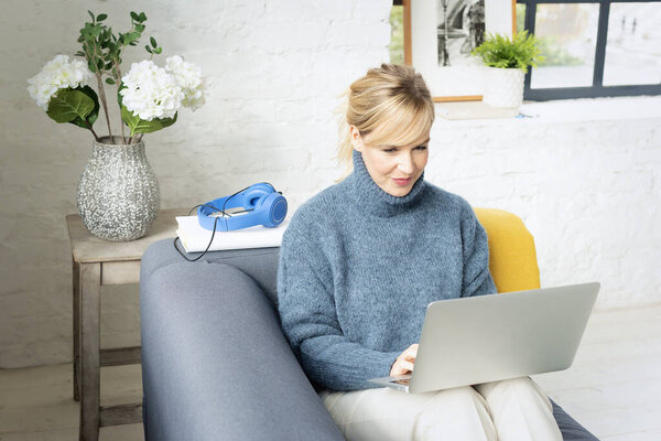 Attractive Mid Aged Woman Using Laptop Home Blond Haired Female Stock Photo