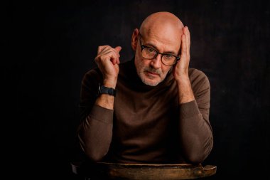 Esmer bir arkaplanda oturan ciddi bir iş adamının portresi. Uzayı kopyala İzole edilmiş arkaplan.