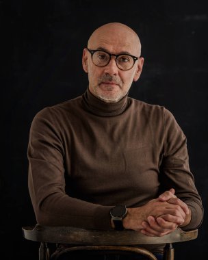 Esmer bir arkaplanda oturan ciddi bir iş adamının portresi. Uzayı kopyala İzole edilmiş arkaplan.