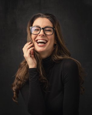 Çekici orta yaşlı bir kadının izole edilmiş karanlık arka plana gülüşünün stüdyo portresi. Boşluğu kopyala.